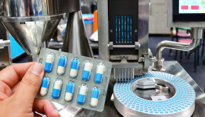 hand-holding-blue-capsule-pack-medicine-pill-production-line-industrial-pharmaceutical-concept_6